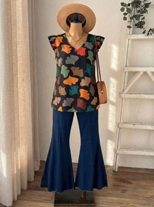 Detail of V-neck ruffle blouse with gingko leaf print and vintage flared denim pants