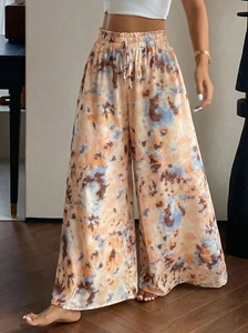 Detail of high-waisted tie-dye wide leg pants with adjustable drawstring waist and fluid drape