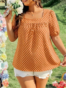 Close-up of square neckline and puff sleeves on navy blue polka dot plus size blouse