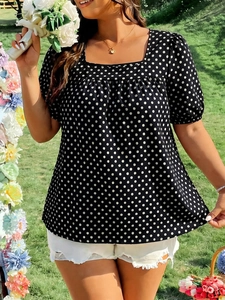 Detail of square neck polka dot blouse with puff sleeves on sunny outdoor lawn