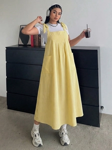 Detail of yellow striped pinafore dress with shoulder bows and large side pockets