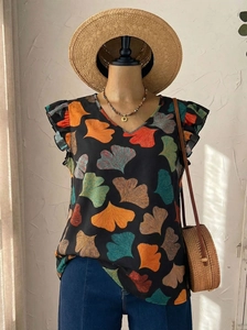 Detail view of V-neck top with colorful ginkgo leaf print and ruffle shoulder accents