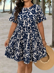 Détail de robe imprimé feuilles bleu marine avec manches volantées et jupe à étages