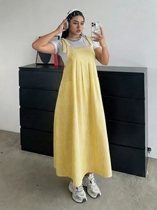 Detail of yellow corduroy striped overall dress with vertical ribbed texture and loose fit