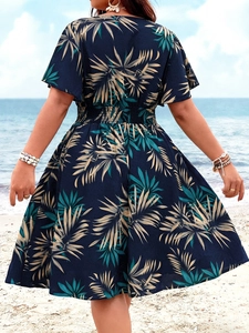 Detail von V-Ausschnitt und elastischer Taille am dunkelblauen Tropen-Print Kleid