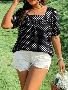 Detail of square neckline and puff sleeves on a navy polka dot plus size blouse