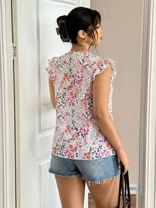 Detail of floral chiffon blouse featuring flutter sleeves and colorful flower pattern