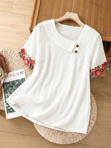 Detailed embroidery on cuffs and asymmetric collar with buttons on a beige summer top