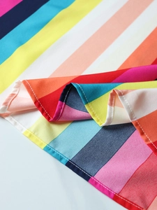 Macro detail of rainbow striped chiffon fabric showing neat hem stitching and texture