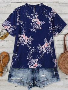 Mise à plat d'un haut en mousseline fleurie bleu marine avec un short en jean bleu