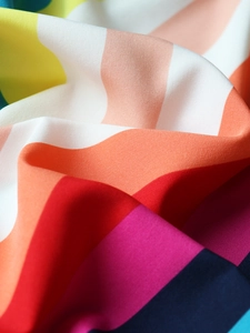 Close-up detail of smooth striped chiffon fabric with vibrant multicolored patterns