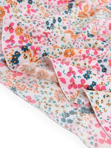 Close-up of lightweight chiffon fabric with floral print and fine edge stitching detail