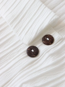 Macro shot of white pleated fabric texture with dark brown wood-style buttons
