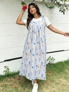 Nahaufnahme eines geblümten Trägerkleids mit weißem T-Shirt für einen lässigen Sommerlook