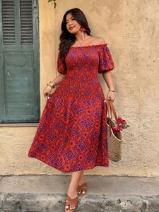 Detail of off-the-shoulder maxi dress featuring red geometric print and smocked waistline