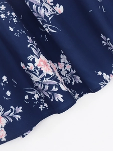 Détail du tissu en mousseline bleu foncé avec imprimé fleuri rose et ourlet surpiqué