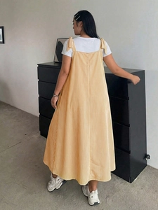 Detail view of the yellow striped dress back with adjustable bow shoulder straps