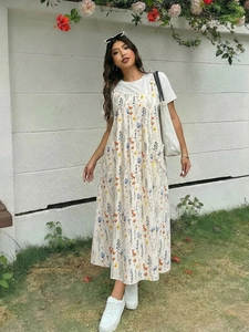 Detailaufnahme vom Sommer-Trägerkleid in Übergröße mit blauem Blumenmuster und Taschen