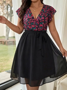 Detail of floral V-neck dress with ruffle sleeves and waist tie on a model