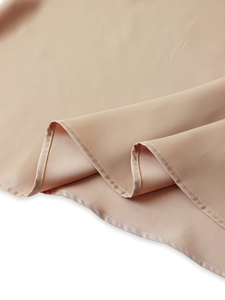 Détail du tissu satiné kaki montrant des coutures raffinées et une texture lisse
