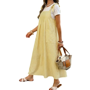 Relaxed yellow striped pinafore dress with bow straps and pockets over a white tee