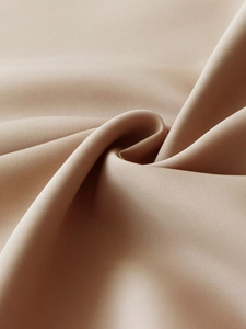 Vue macro du tissu de chemise kaki montrant sa texture soyeuse et son drapé élégant