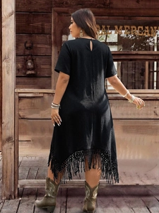 Detail view of black bohemian dress featuring a keyhole back and long fringe hem details
