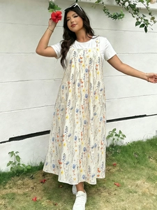 Outdoor-Lifestyle-Ansicht eines losen Blumen-Trägerkleids mit weißem T-Shirt und Seitentaschen