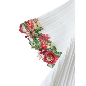 White ethnic style t-shirt featuring intricate colorful floral embroidery on the sleeve