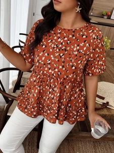 Detail of orange floral chiffon top featuring tiered peplum hem and vibrant summer print