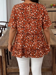 Detail of ruffle hem and abstract floral print on a rust-red chiffon summer top