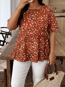 Detail of orange floral chiffon top featuring a tiered ruffle hem and relaxed round neck