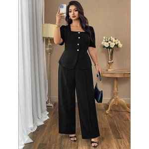 Detail of black square neck top with gold buttons and matching wide leg high-waist trousers