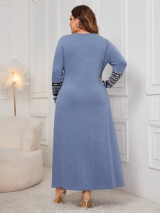 Detail of blue long-sleeve dress featuring ethnic geometric patterns on the cuffs