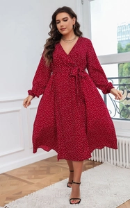 Détail d'une robe maxi rouge à pois avec manches longues, col en V et ceinture à nouer