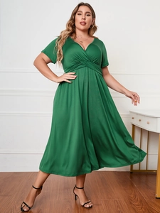 Detail of cross-pleated waist on a dark green plus-size V-neck short-sleeve dress
