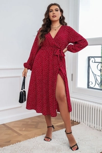 Détail de robe rouge à pois avec décolleté en V, taille nouée et fente haute sur la jambe
