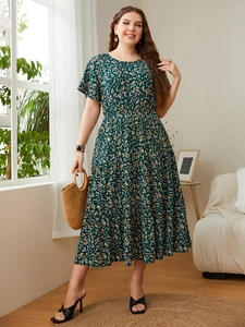 Detail of floral print summer dress with tiered skirt and cinched waist in garden setting