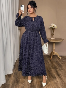 Detail of navy blue polka dot long sleeve dress with waist pleats and neck tie