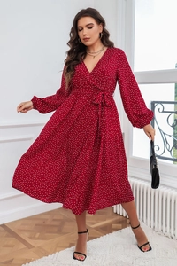 Détail d'une robe cache-cœur rouge à pois avec col en V et ceinture ajustable