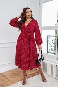Détail de la robe midi rouge à pois montrant le col en V et le nœud à la taille