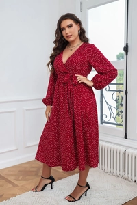 Détail d'une robe rouge à pois avec décolleté en V, taille ceinturée et manches lanternes