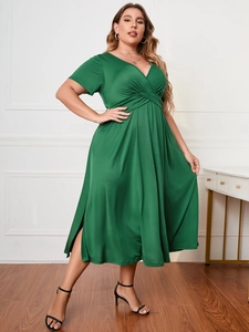 Detail of emerald green short-sleeved dress featuring deep V-neck and twist knot waist