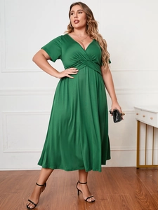 Detail of plus size green V-neck dress featuring elegant waist knot and pleated drape