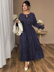 Detail showing navy blue polka dot long sleeve dress with waist tie and ruffled cuffs