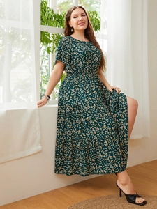 Detail view of the floral print waistline and layered tiered skirt on green dress