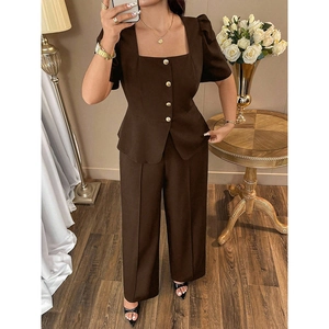 Detail of square neck top with gold buttons and high-waist pleated wide-leg trousers