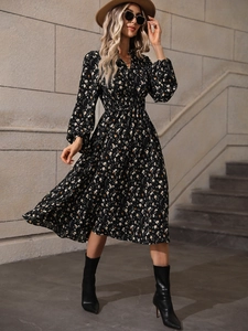 Detail shot of the elastic high waist and puff sleeves on this black floral maxi dress