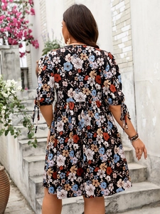 Dettaglio vestito floreale con polsini annodati e vita alta su sfondo nero chic