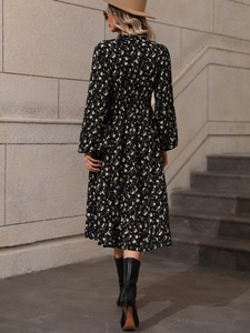 Back view of a black long sleeve floral maxi dress with elastic waist and modest design